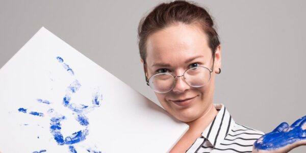 Terapia sztuką jako metoda wspierająca leczenie zaburzeń psychicznych 46 woman with canvas of picture her hand on gray back 2023 11 27 04 58 58 utc e1732694951335